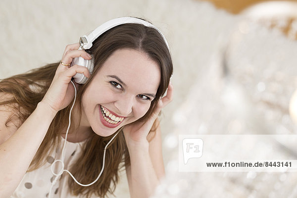Laughing young woman wearing headphones