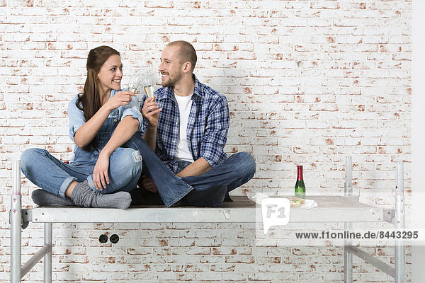 Young couple moving into new home  toasting with champagne glasses