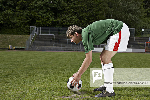 Fußballspieler platziert Ball auf Elfmeterpunkt