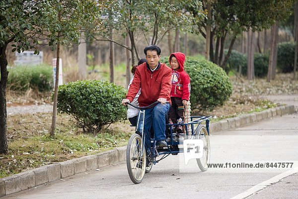Family on a tricycle in Guilin  China. China has a one child family planning policy to reduce population.