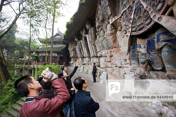 Tourist photographs Anicca  God of Destiny holds wheel of life  Dazu rock carvings  Mount Baoding  China