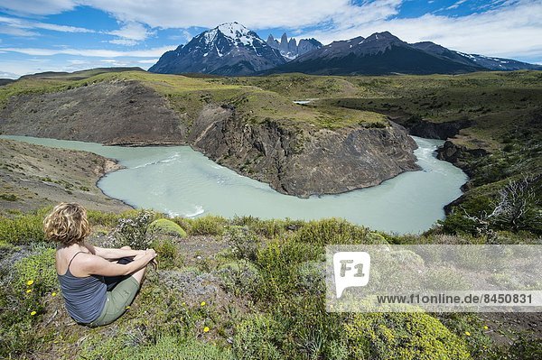 sitzend  Biegung  Biegungen  Kurve  Kurven  gewölbt  Bogen  gebogen  Frau  über  Fluss  frontal  Chile  Patagonien  Südamerika