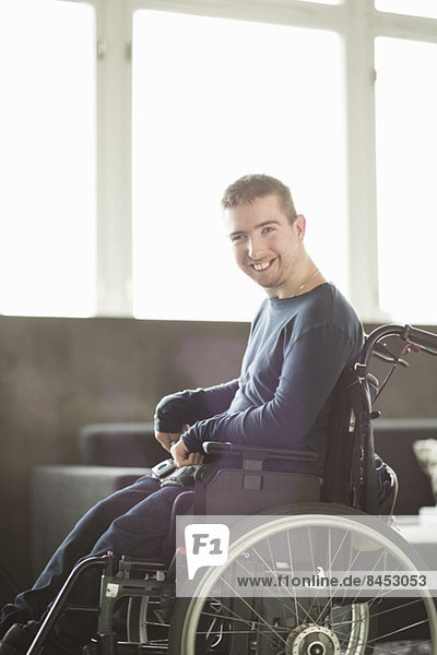 Portrait of happy disabled businessman sitting on motorized wheelchair in office
