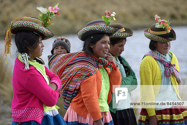 Junge Frauen in bunter  traditioneller Tracht und Baby im Tragetuch  Quispillacta  Ayacucho  Peru