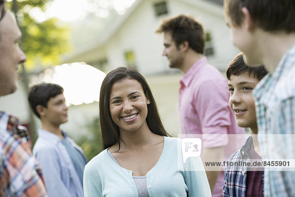 A group of people  adults and teenagers at a summer party.