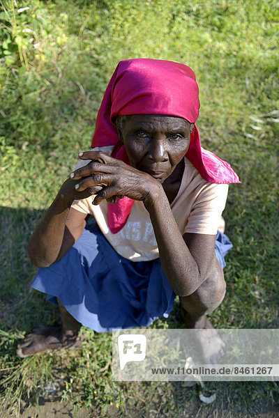 Alte Frau sitzt im Gras  Tchawa  Leogane  Haiti