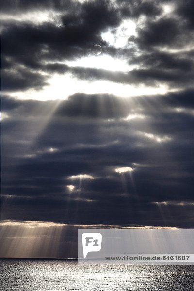 Sonnenstrahlen scheinen durch dunkle Gewitterwolken  Fuerteventura  Kanarische Inseln  Spanien