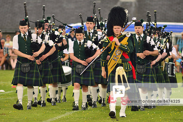 Pipe Band angeführt vom Pipe Major auf dem Sportplatz bei den Highland Games  Dufftown  Moray  Highlands  Schottland  Großbritannien