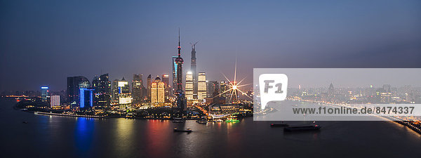 Skyline Finanzviertel mit Oriental Pearl Tower  Shanghai Tower  Pudong mit Fluss Huangpu in der Abenddämmerung  Shanghai  China