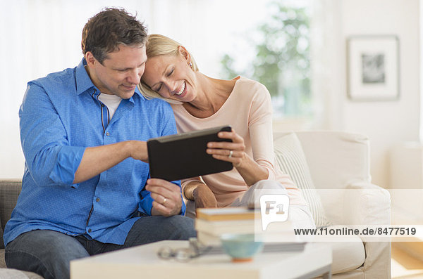 Couple using tablet pc at home