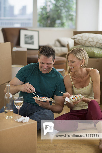 Couple eating sushi in new home
