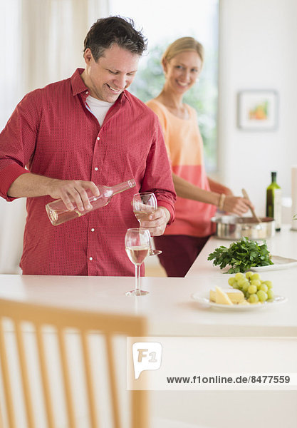 Couple cooking at home  man pouring wine