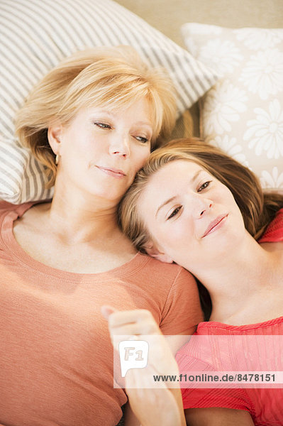 Mother and adult daughter relaxing on floor