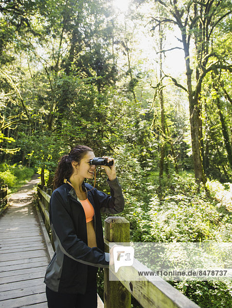Portrait of woman looking at view with binoculars