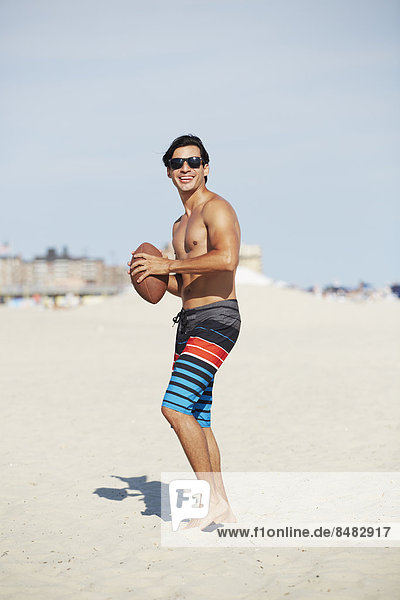 Man playing with football on beach