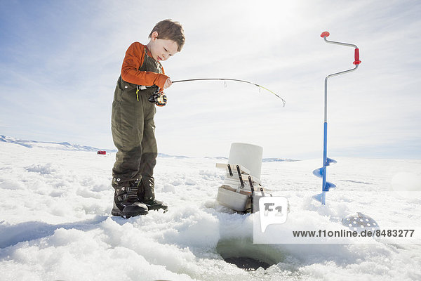 Caucasian boy ice fishing