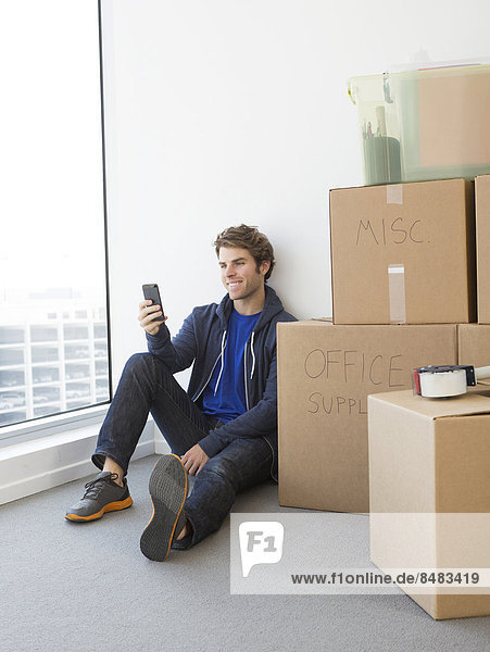 Caucasian man with cardboard boxes in new home