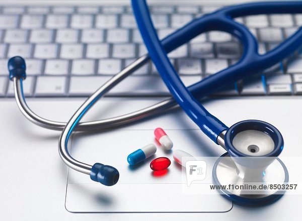 Stethoscope and medicine on laptop computer still life