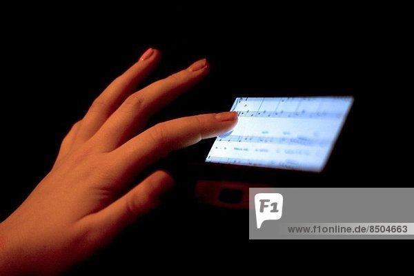 Nahaufnahme der Hand über Touchscreen mit Notenanzeige