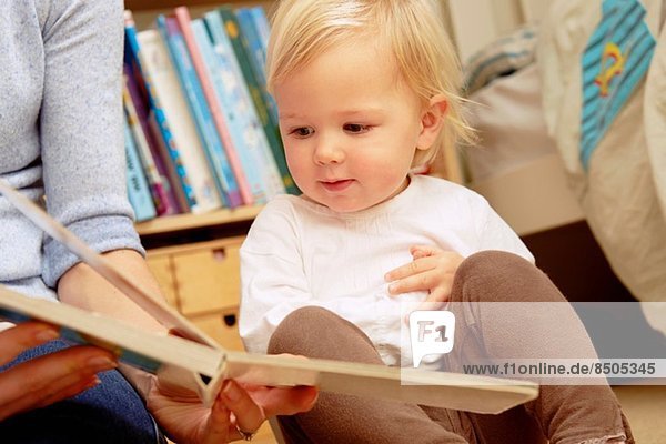 Mutter liest Bilderbuch mit Baby-Tochter