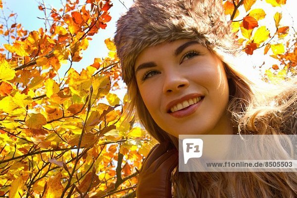 Junge Frau mit Pelzmütze im Herbstpark