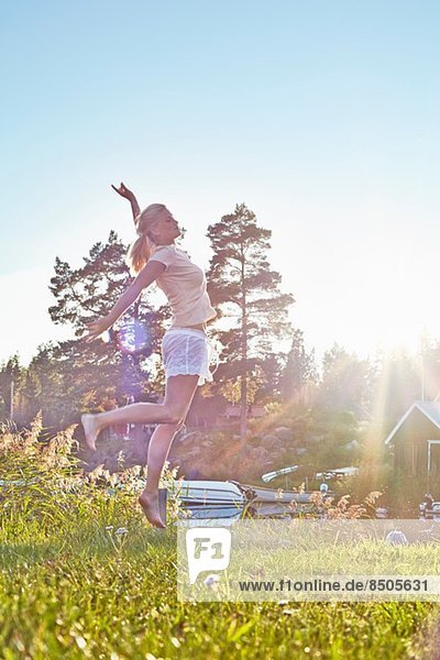 Junge Frau springt am See,  Gavle,  Schweden