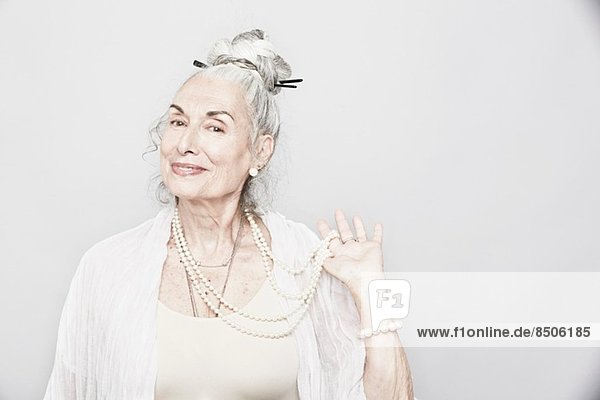 Studio-Porträt der anspruchsvollen Seniorin mit Perlen