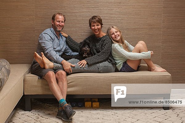 Porträt von Eltern und Tochter auf dem Sofa