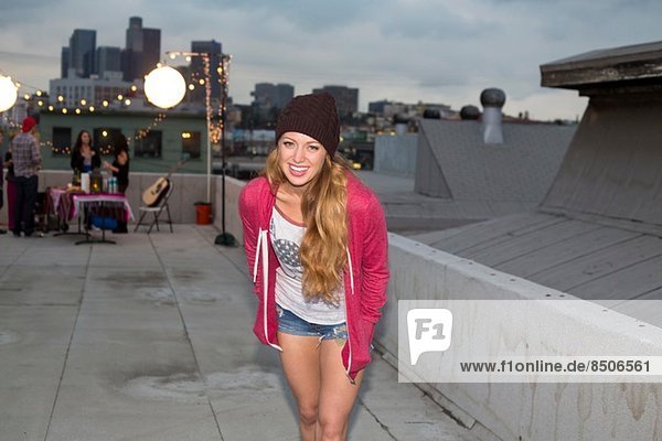 Young woman in wool hat at rooftop barbecue