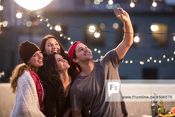 Young adult friends taking self portrait at party