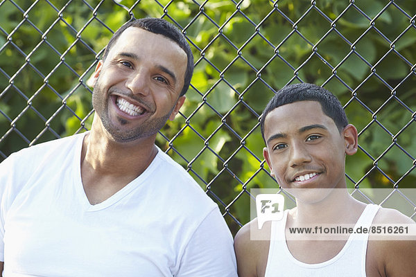 Hispanic father and son smiling outdoors