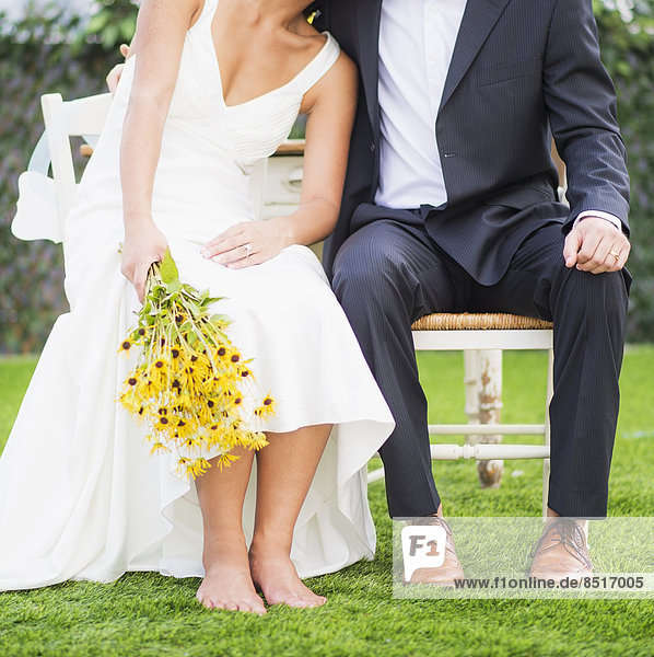 Newlywed couple sitting outdoors