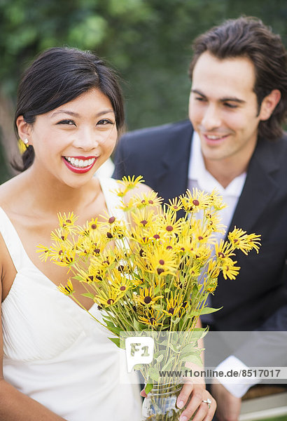 Newlywed couple holding bouquet