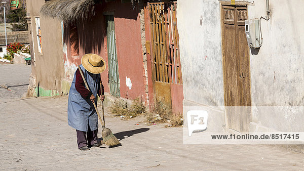 Woman sweeping outside her house  Putre  northern Chile