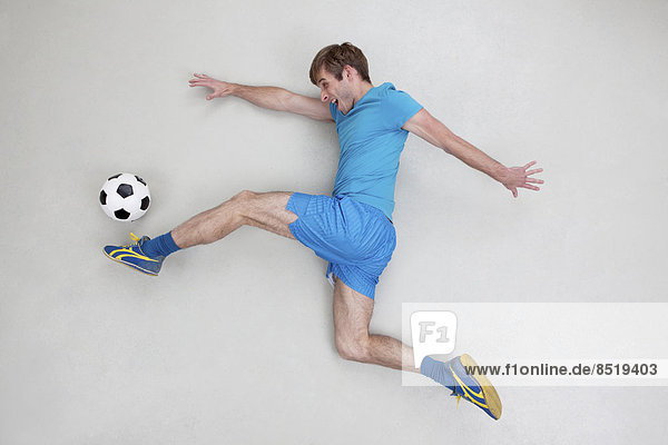 Man kicking football