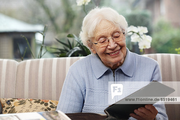 Lächelnde Seniorinnen beim Betrachten alter Fotos zu Hause