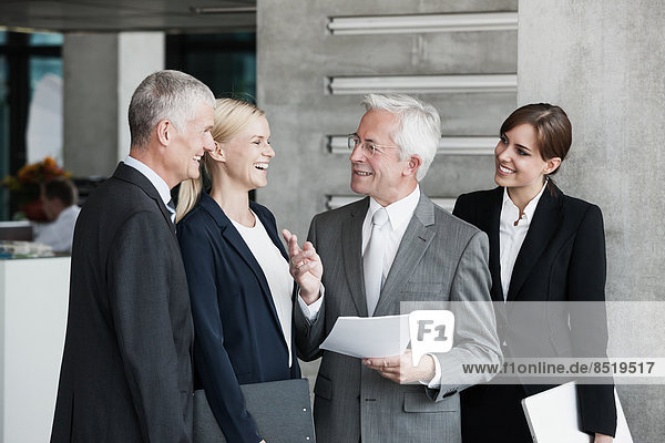 Lächelnde Geschäftsleute sprechen im Büro