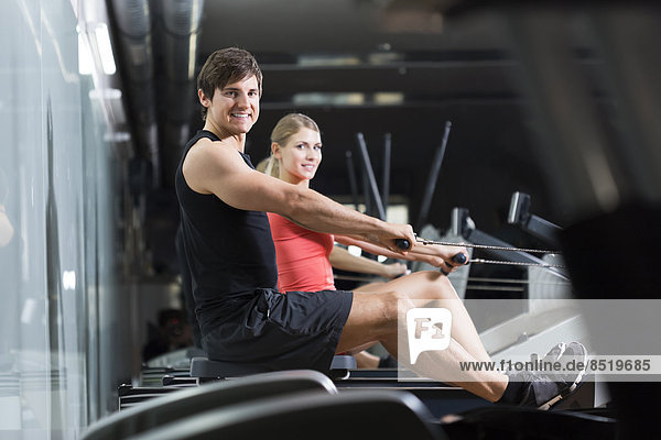 Austria  Klagenfurt  Man and woman exercising with rowing machine