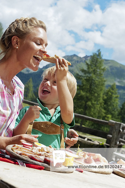 Austria  Salzburg State  Altenmarkt-Zauchensee  mother and son haßing an alpine picnic