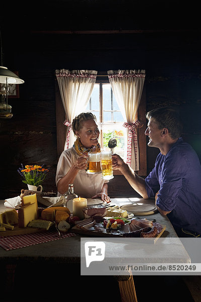 Austria  Salzburg State  Altenmarkt-Zauchensee  couple haßing an alpine picnic at alpine cabin