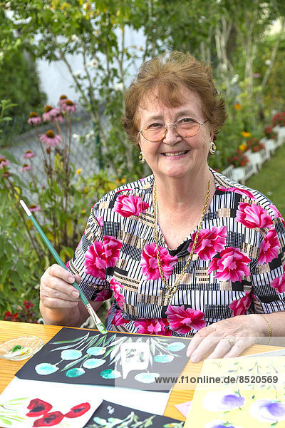 senior woman painting in garden