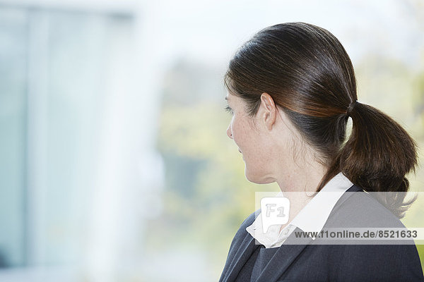Reife Geschäftsfrau mit Blick aus dem Fenster