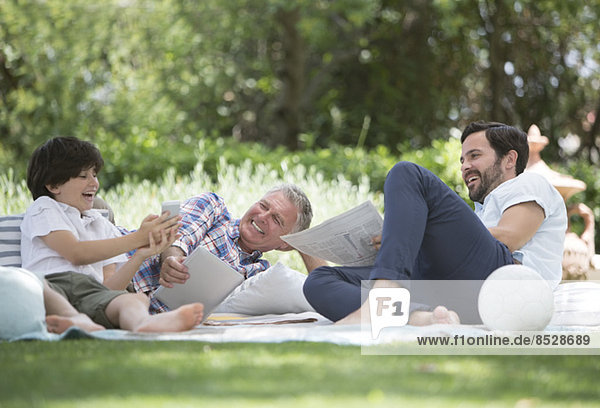 Mehrgenerationen-Männer entspannen auf der Decke im Garten
