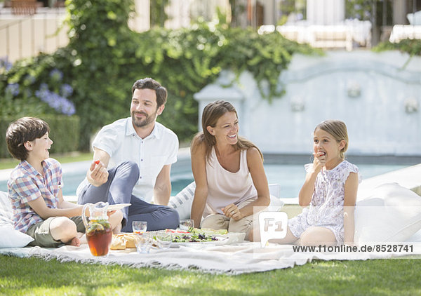 Familie genießt Picknick im Gras