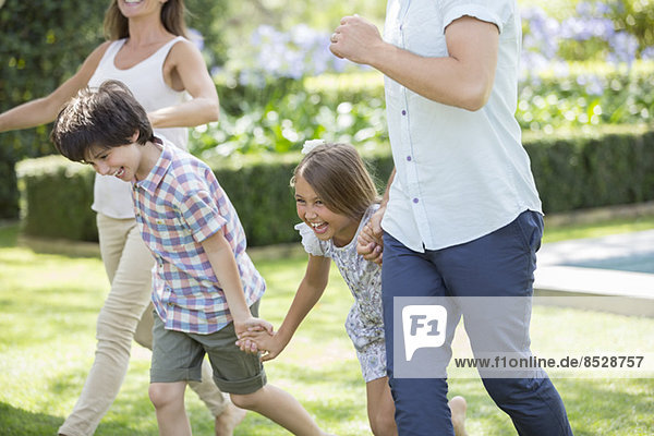Familie beim Händchenhalten und Laufen im Hinterhof
