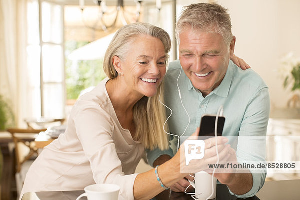 Seniorenpaar mit mp3-Player in der heimischen Küche