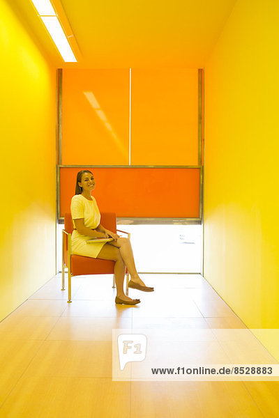 Geschäftsfrau sitzt in hellem Büro
