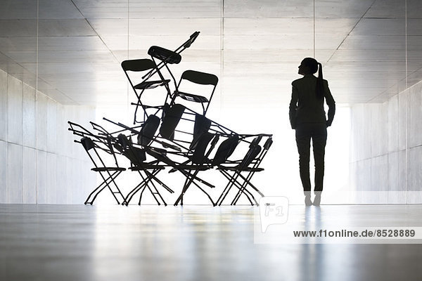 Geschäftsfrau untersucht Bürostuhl-Installationskunst