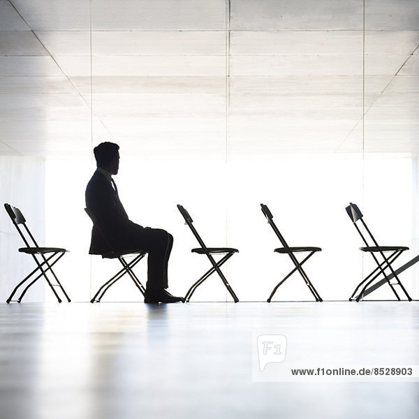 Silhouette eines im Büro sitzenden Geschäftsmannes