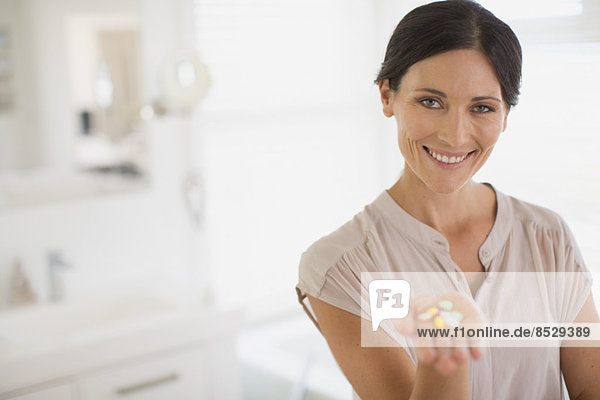 Woman holding handful of pills